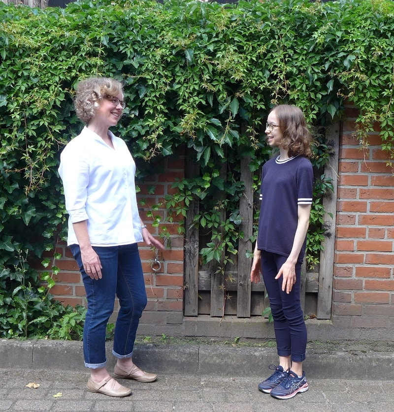 Julia Verlinden und Paula Heide vor einer begrünten Häuserwand